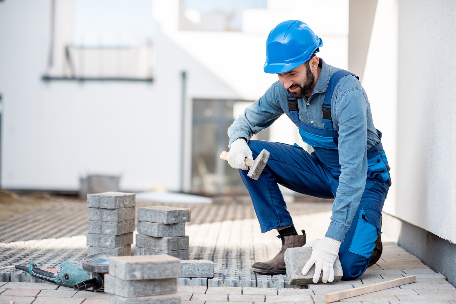 Builder laying paving tiles